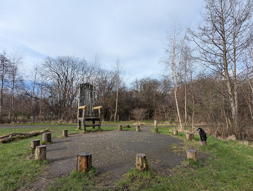 A small black terrier dog on a walk at Dalmarnock.